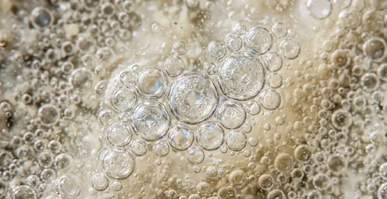 Photographie macro de gouttelettes d'eau dans une émulsion cosmétique montrant la texture et la structure à l'échelle microscopique