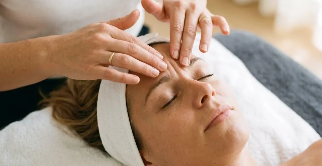 Gros plan sur des mains effectuant un massage facial doux entre les sourcils pour attenuer la ride du lion