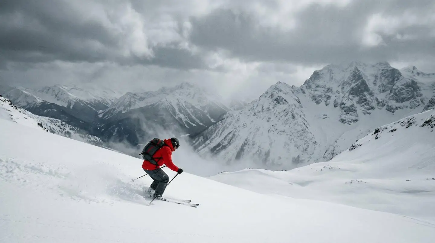 Skieur équipé d'une veste technique imperméable dans un environnement de haute montagne enneigé sous conditions de froid extrême